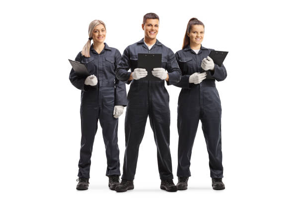 A team of three smiling home inspectors in dark blue uniforms and protective gloves, each holding a clipboard, representing the professional staff of Garden Home Inspection.